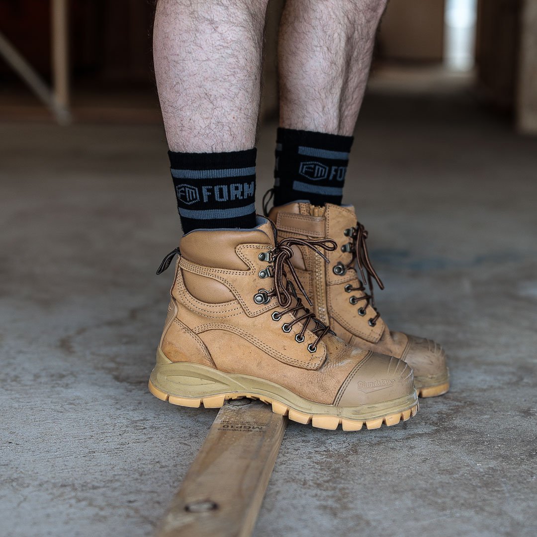 Form Workwear black socks worn with tan steel-toe work boots, ideal for tradesmen seeking comfort and durability