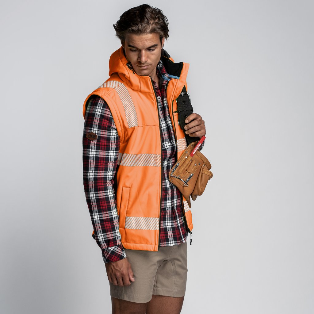 Tradesman in hi-vis orange Form Workwear vest holding a tool belt